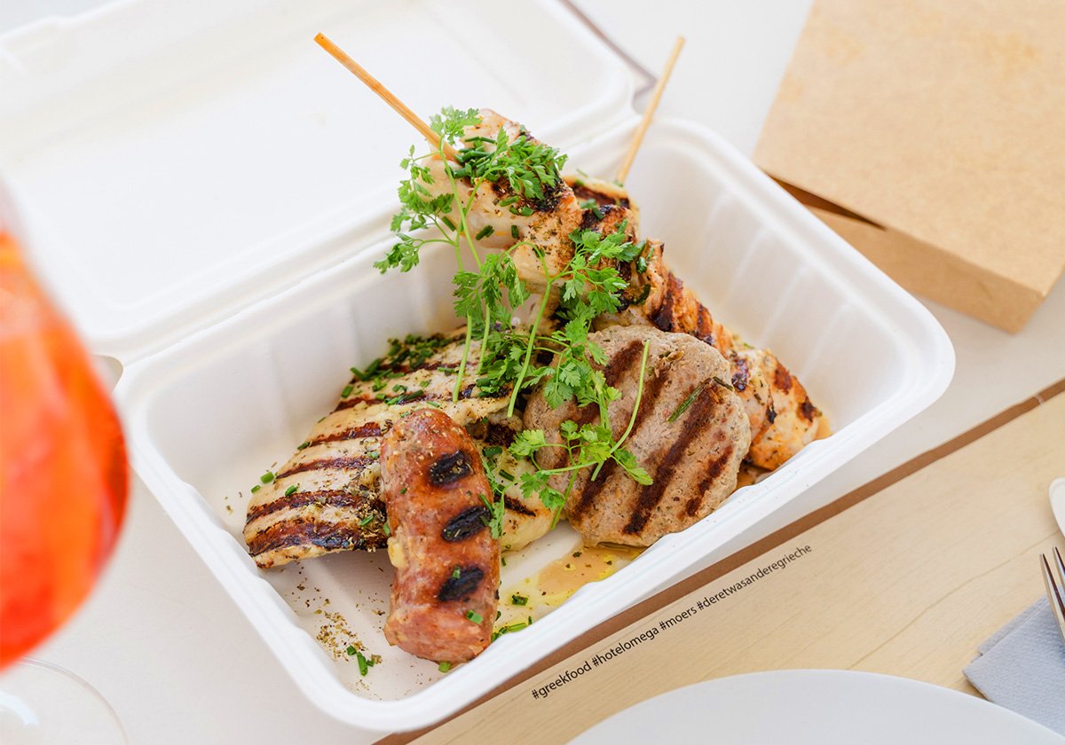 Griechischer Grillteller mit Souvlaki und Bifteki in der Takeaway-Box vom Restaurant Omega Moers